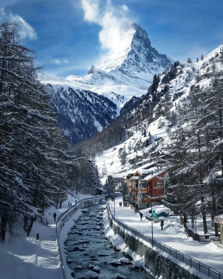 Panorama enneigé de Zermatt avec le Cervin, chalets de prestige dans une station de luxe.