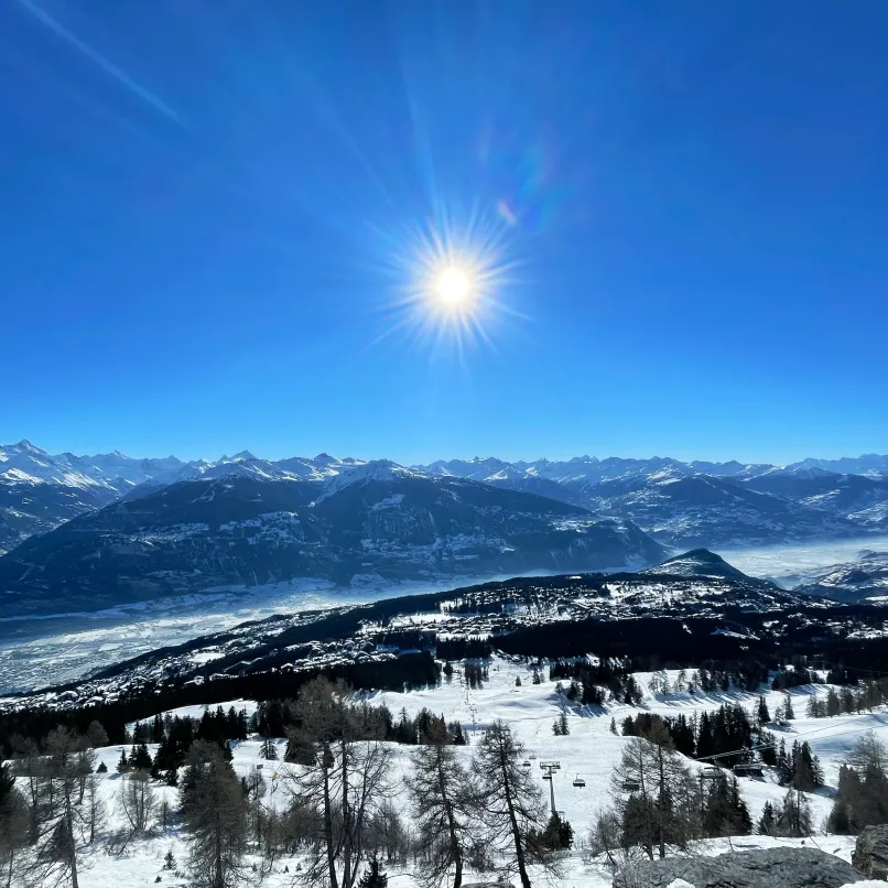 Vue panoramique enneigée de Crans-Montana, propriétés de luxe en station de ski.