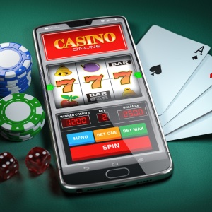 a mobile phone on a green background, with playing cards on the right and poker chips on the left showing 3 matching 7s on the reels