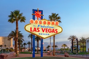 The Las Vegas strip at night lit up in neon lights with a dark background