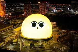 An image of a giant earth looking sphere with people standing around looking at it at night