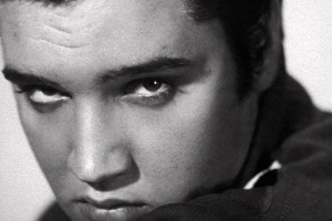 A black and white image of Elvis close up