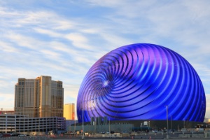 A close up image of the Sphere lit up purple and blue during the day