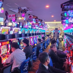 An image of a room full of people playing Pachinko machines