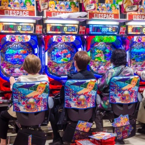 A close up of people playing on Pachinko machines