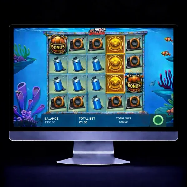 An image of a silver mac monitor on a black background with a RAZOR SHARK themed online slot game image on the screen