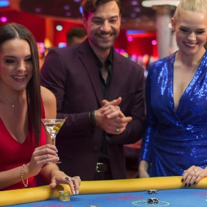 A group of males and females dressed up playing baccarat together