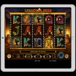 An image of a silver ipad on a black background, on the screen is an online slot game image of LEGACY OF DEAD