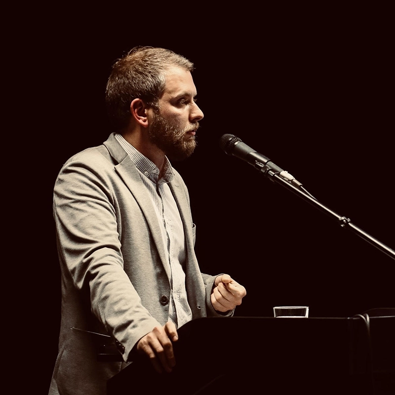Martin at a podium speaking into a microphone