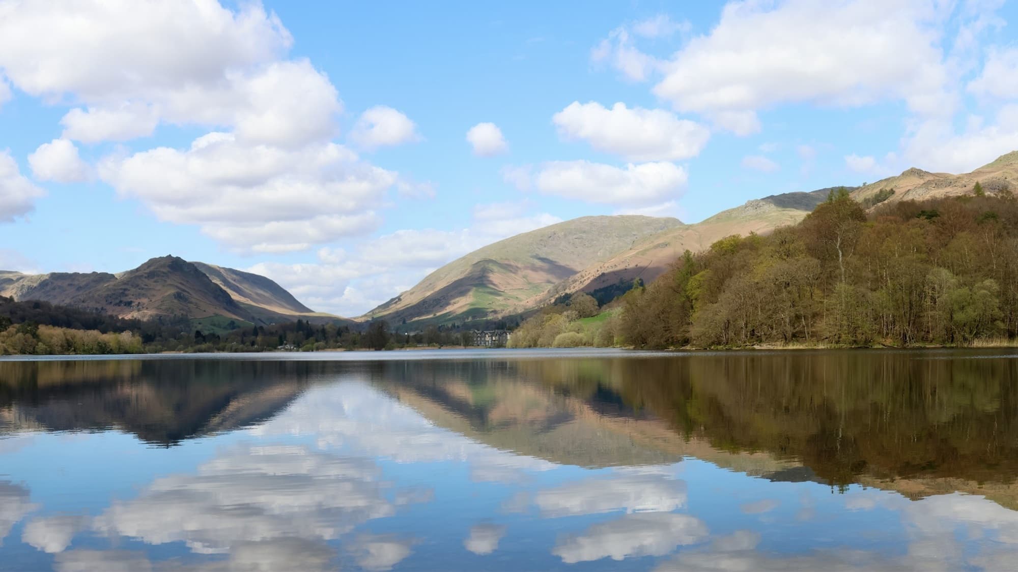 Grasmere lake with reflections of surrounding fells and trees, Lake District