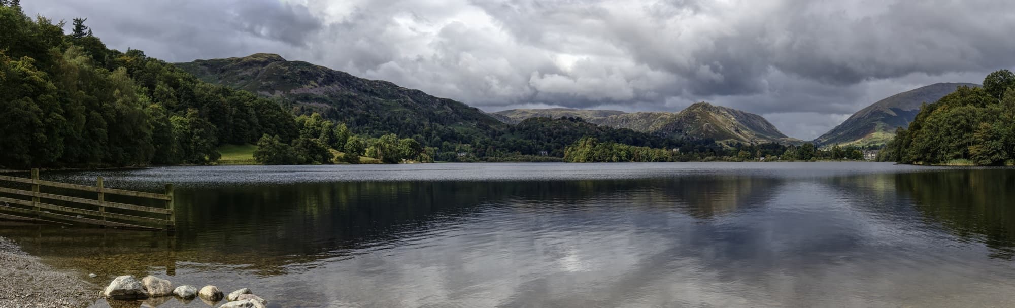 View across Grasmere lake from the shoreline with surrounding fells, Lake District