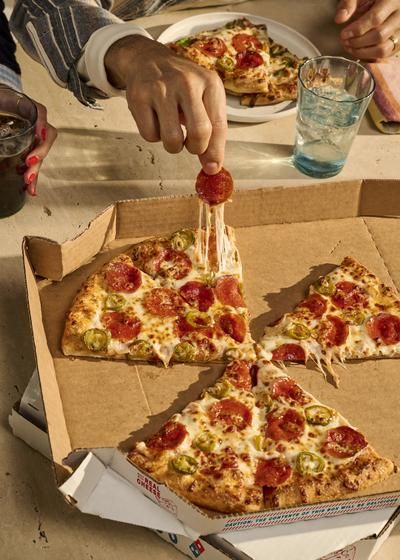Two friends laughing and having pizza at table