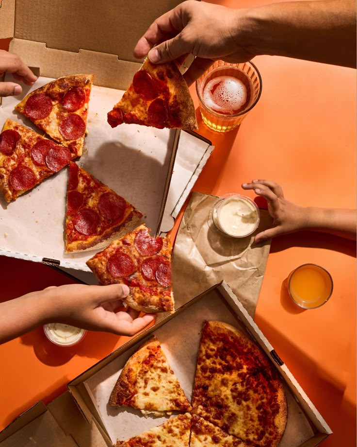 A little boy eating a big pizza and drinking water