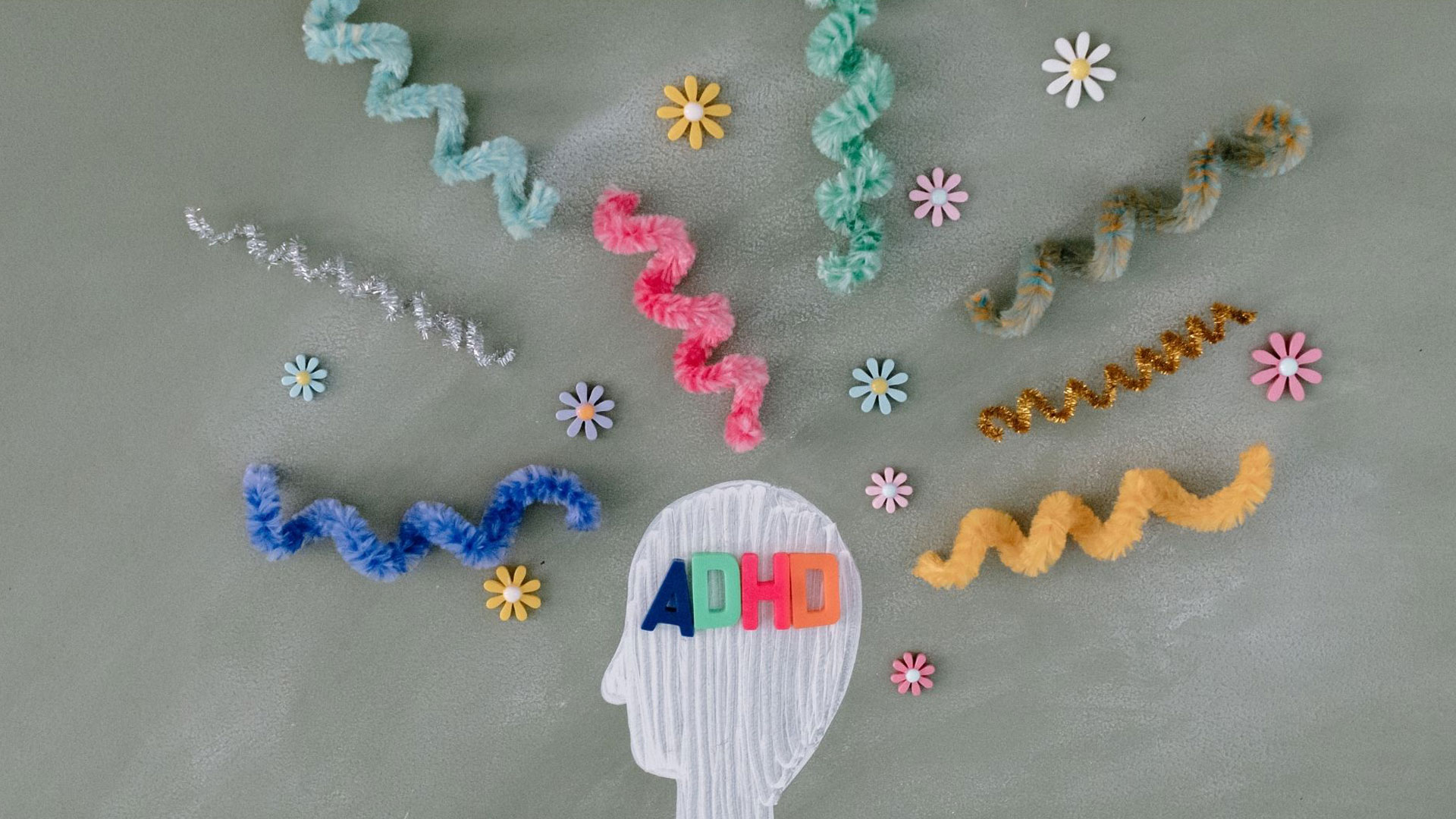 picture of a white head with adhd written on it in in multiple colors with coils and spirals coming out from all directions.