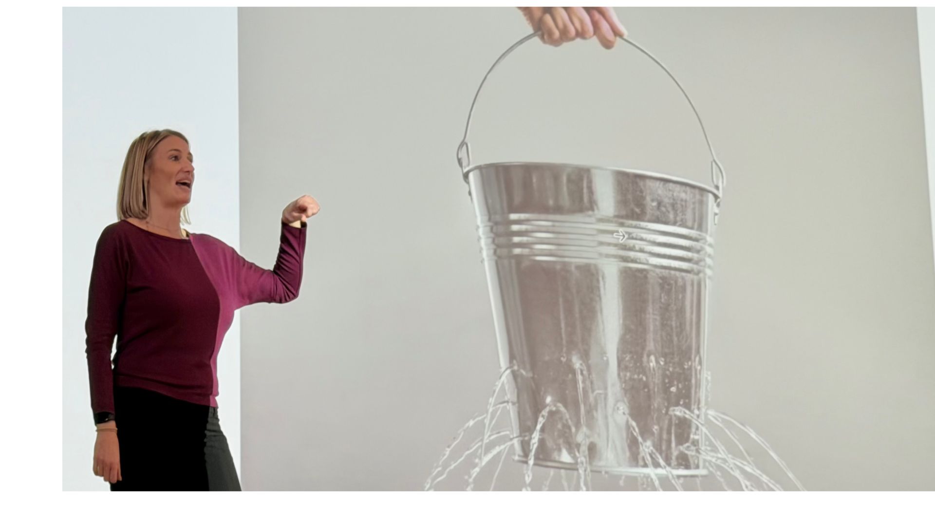 Leadership coach Jane Singleton presenting beside a bucket draining water, illustrating how overwhelm depletes cognitive capacity and derails career decision-making for neurodivergent adults and leaders.