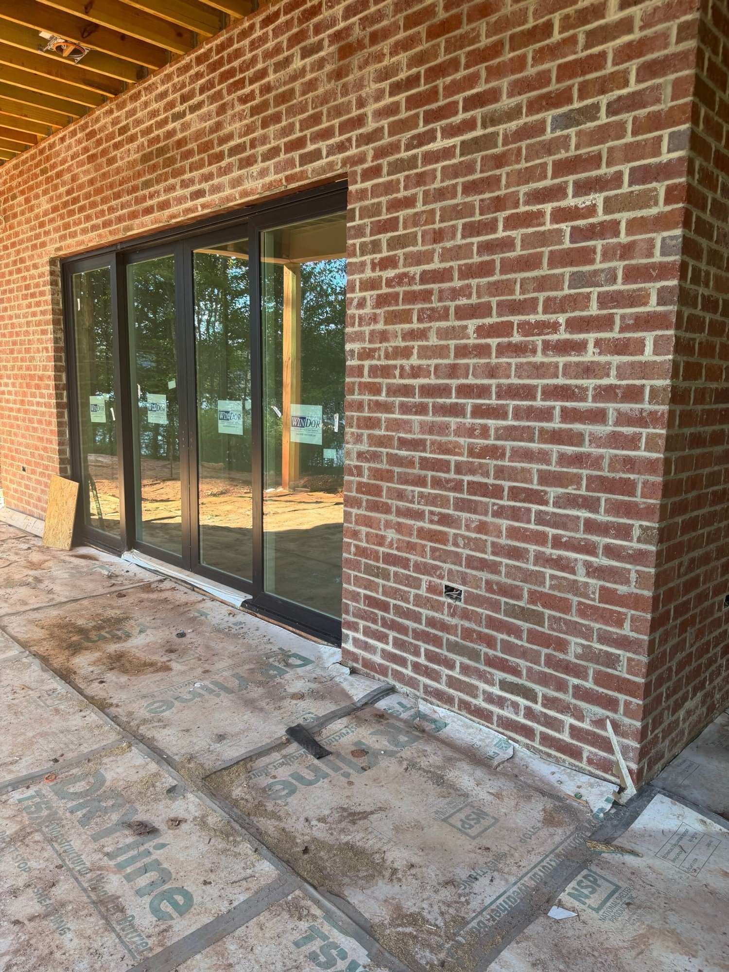 Brick wall beside a wide sliding glass door opening onto a covered patio in McLean, Clover SC.
