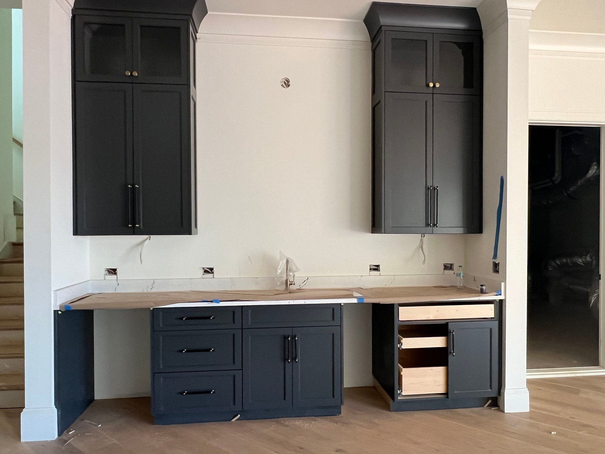 Navy blue upper and lower cabinets along a white wall.
