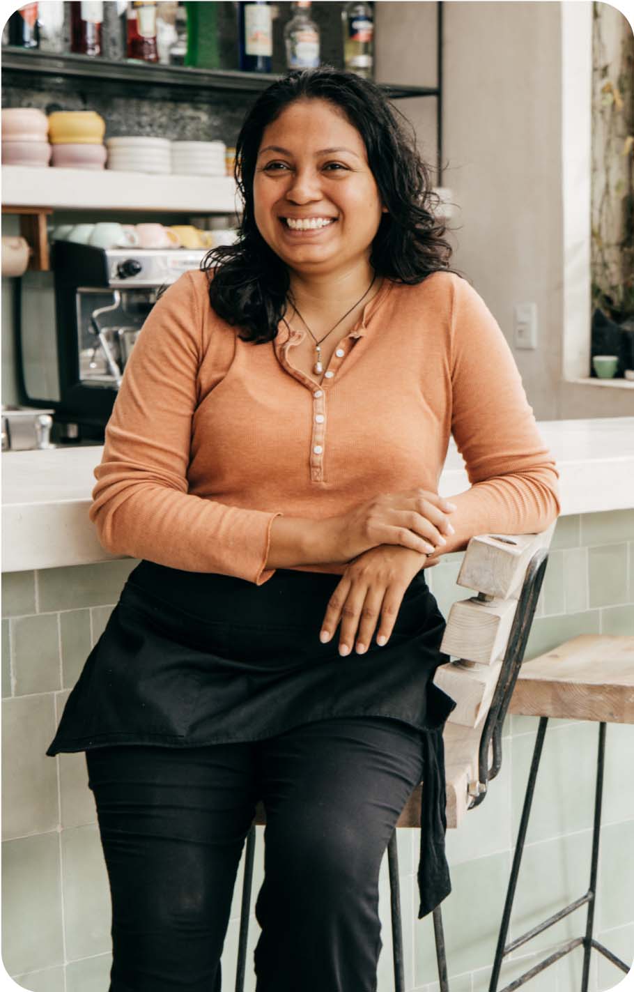 A woman at a bar smiling at the camera