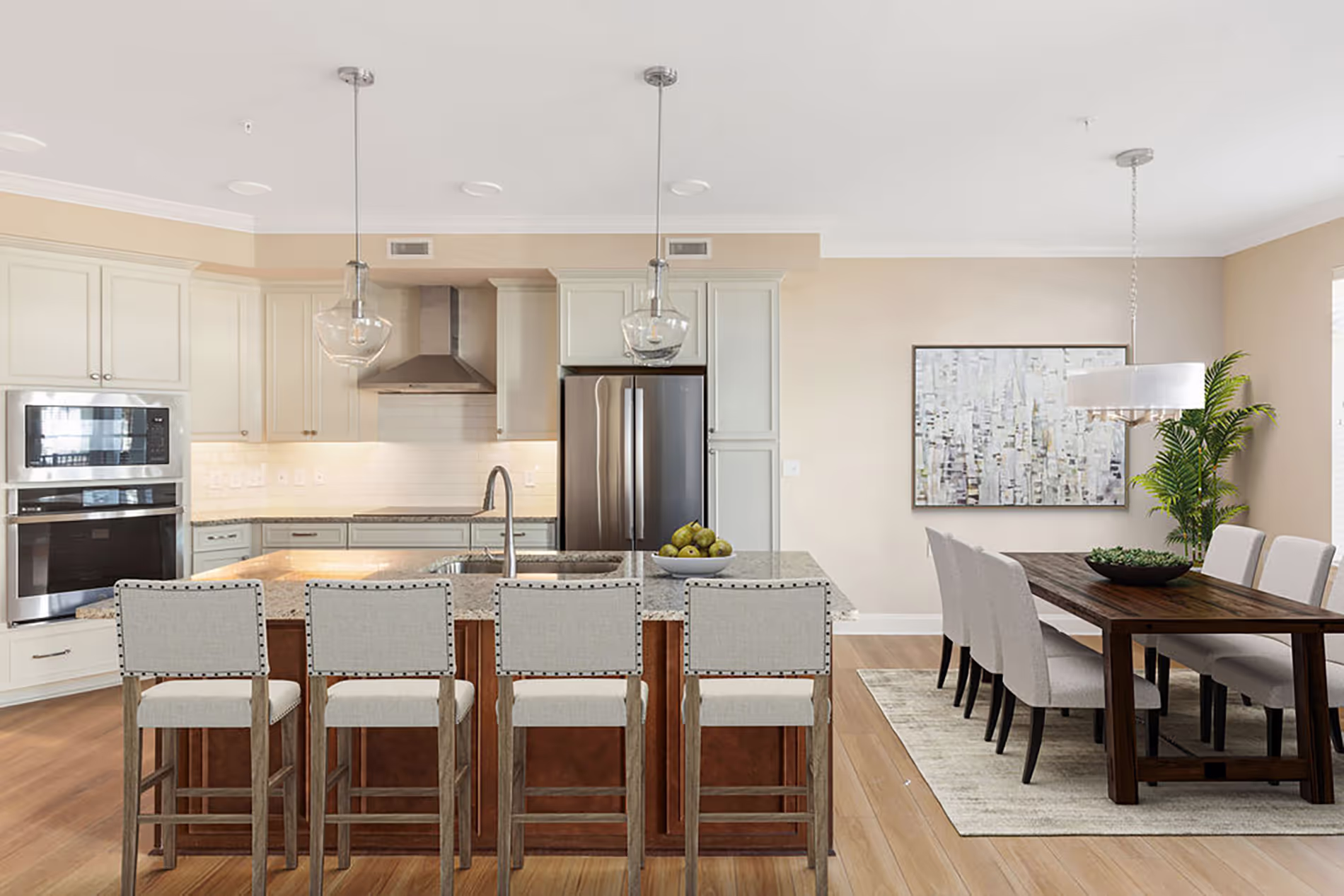 Modern kitchen with a large island and bar stools, adjacent to a dining table with eight chairs.