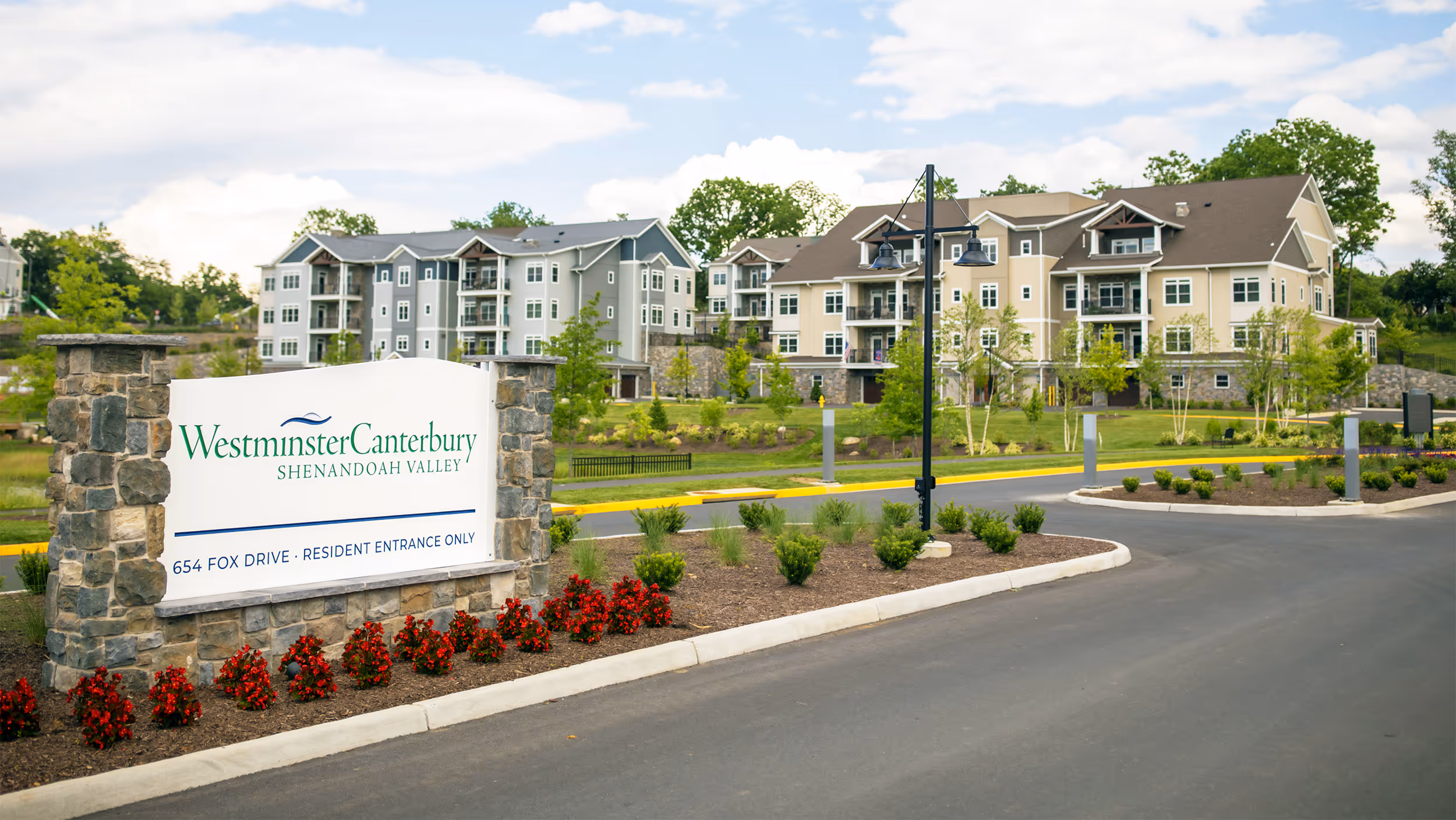 Sign reads "Westminster Canterbury Shenandoah Valley" in front of large residential buildings with greenery.