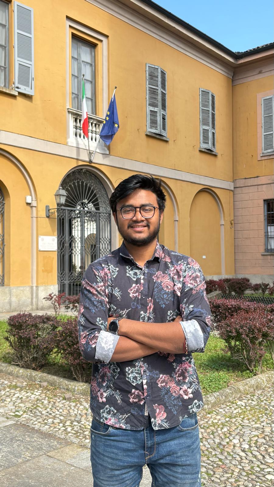 Aneek Das in front of a university building in Pavia, Italy