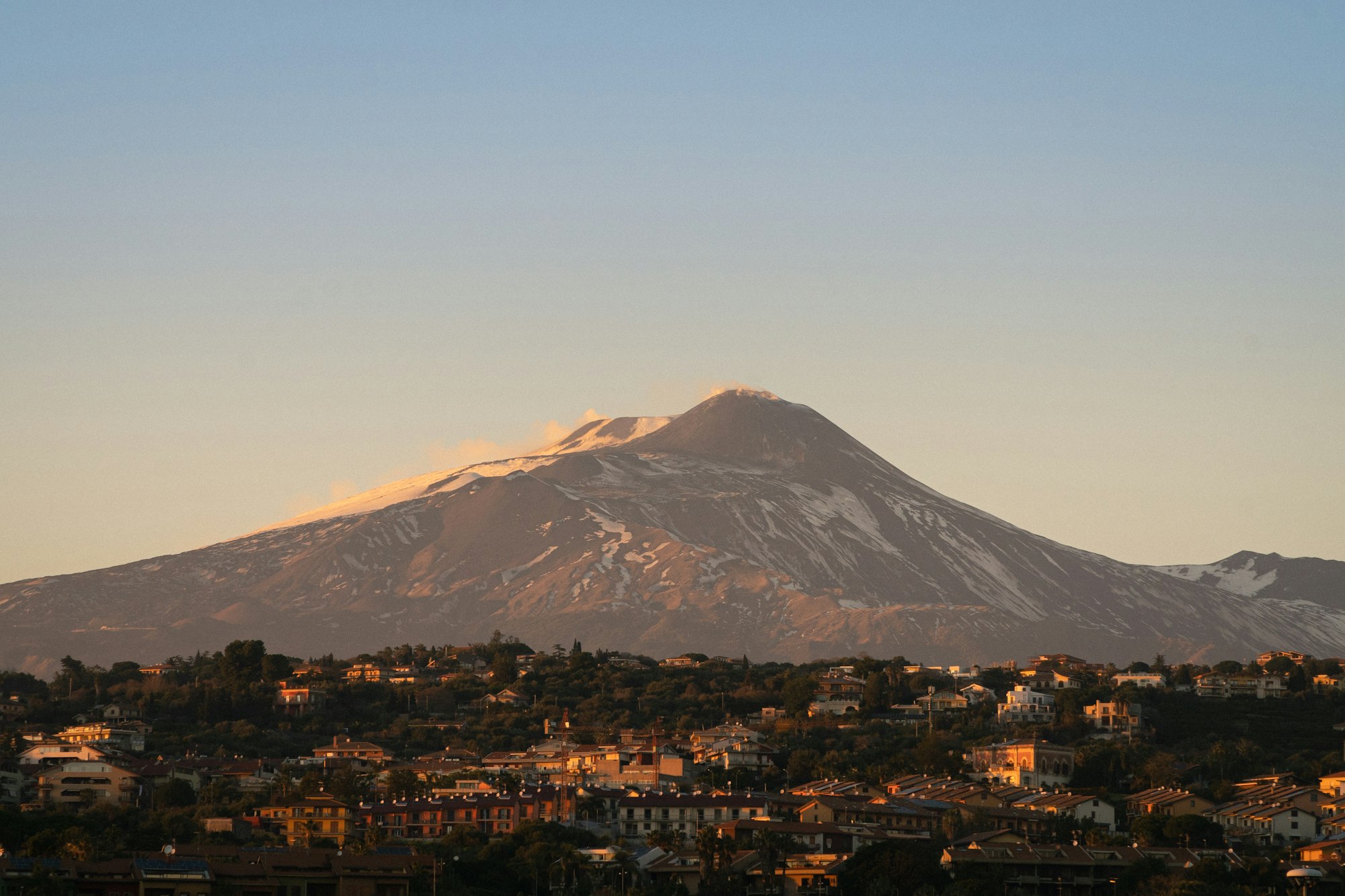 Snow-capped Mount Etna above Catania at sunset