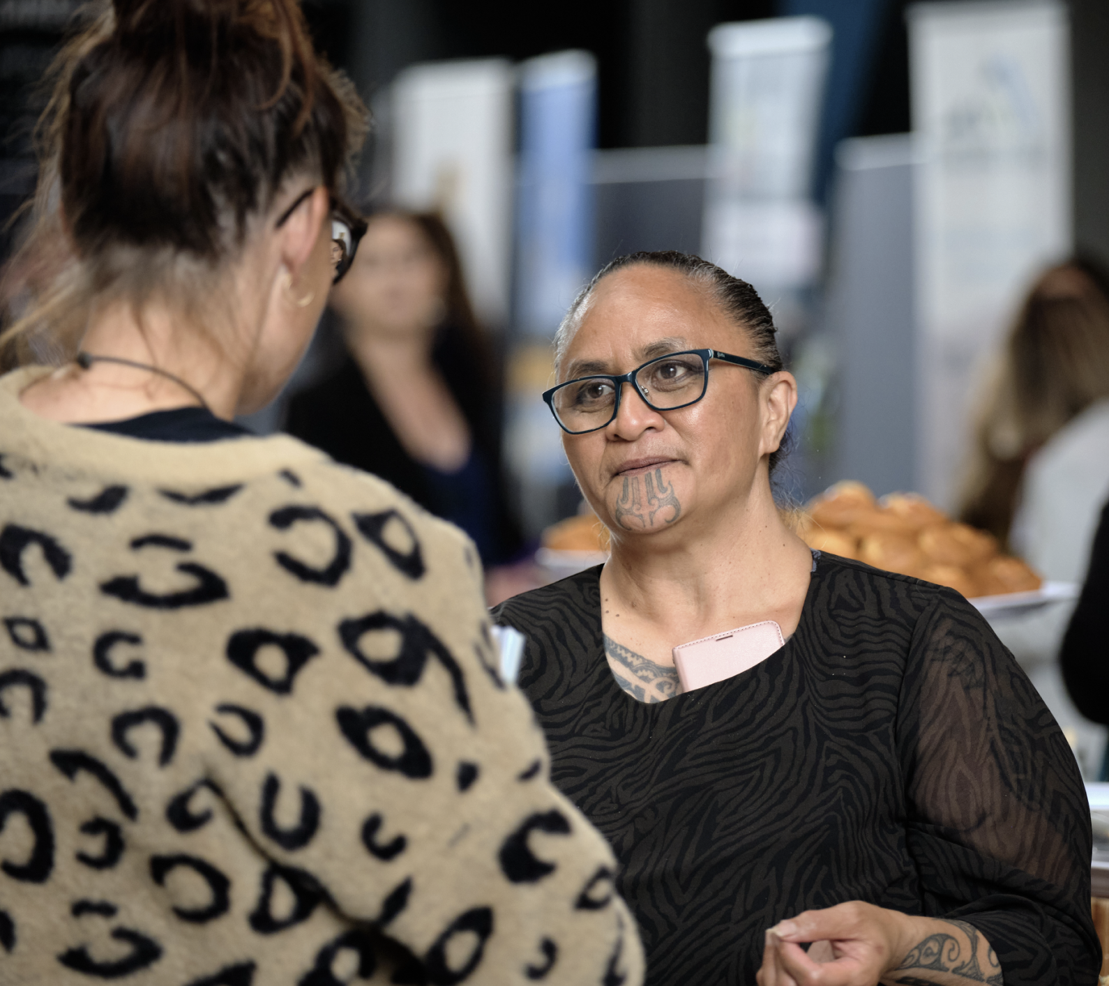 Maori woman talking to someone at a business conference