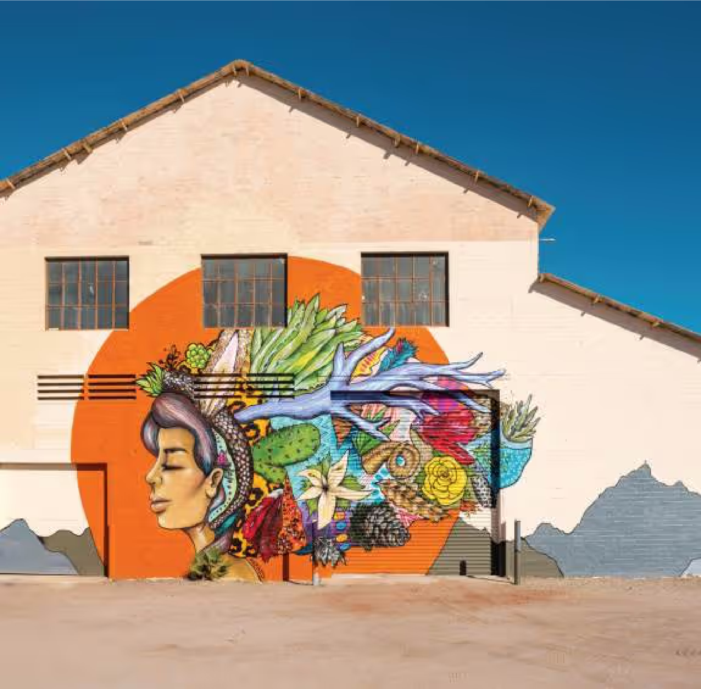 Colorful street art mural of woman with nature elements on building wall