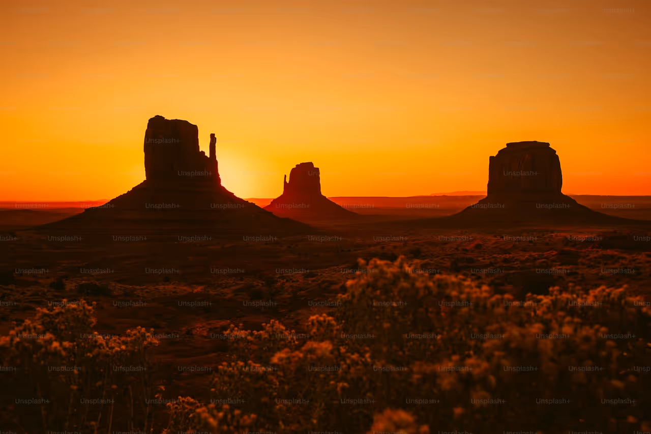 Monument Valley sunset with iconic rock formations in golden orange light