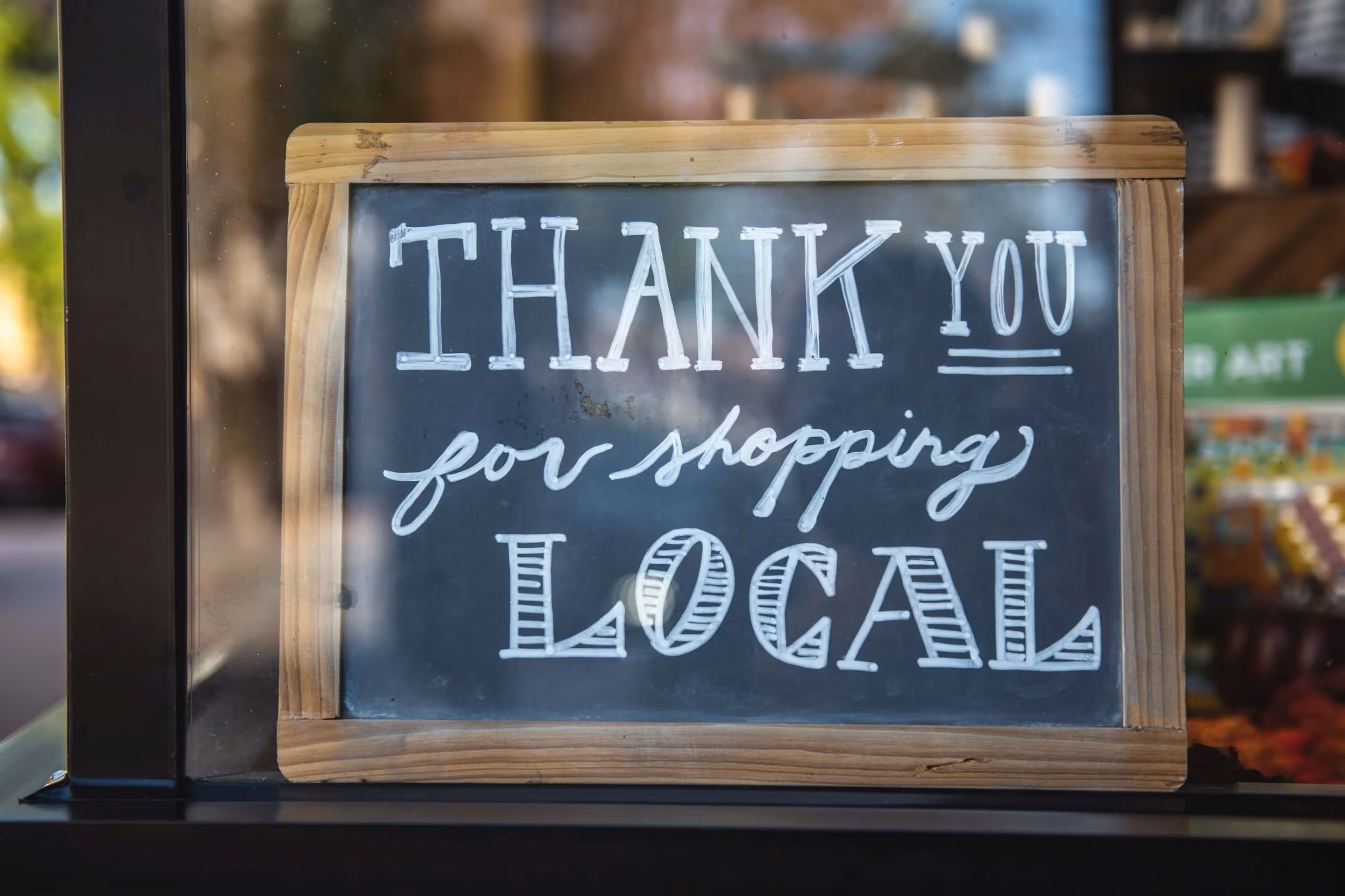 Chalkboard sign saying "Thank you for shopping local"