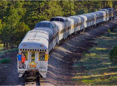 Passenger train on curved tracks through wooded green landscape