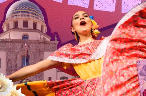 Woman in colorful traditional Mexican dress dancing with a historic domed building in the background.