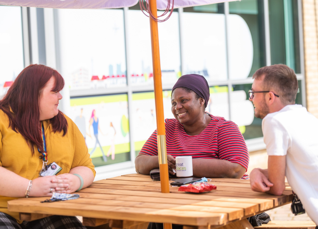 Great Places employees gathered around table outside office