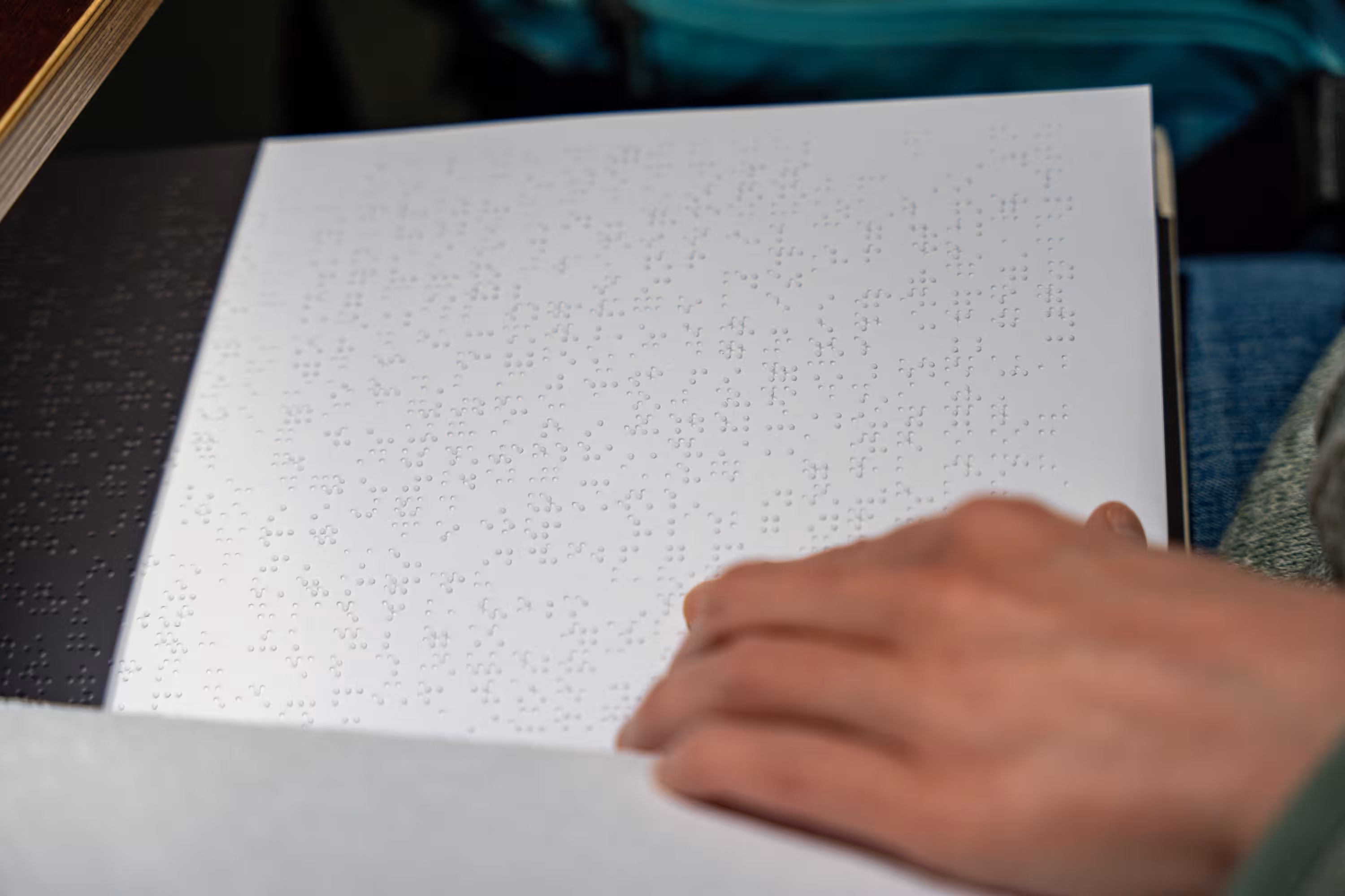 Ehrenamtliche von Sehbehindert – aber Richtig e.V. liest Braille-Schrift beim Secondhand-Basar in München