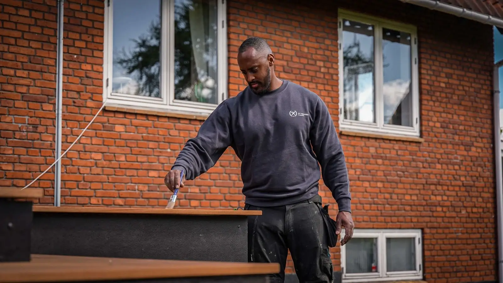 Tømrer giver træterrasse olie med pensel for flot afslutning og finish