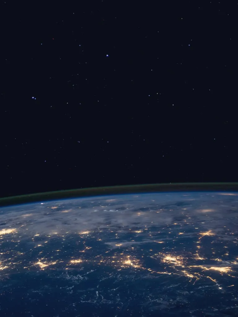 A view of Earth from space, with stars above it.