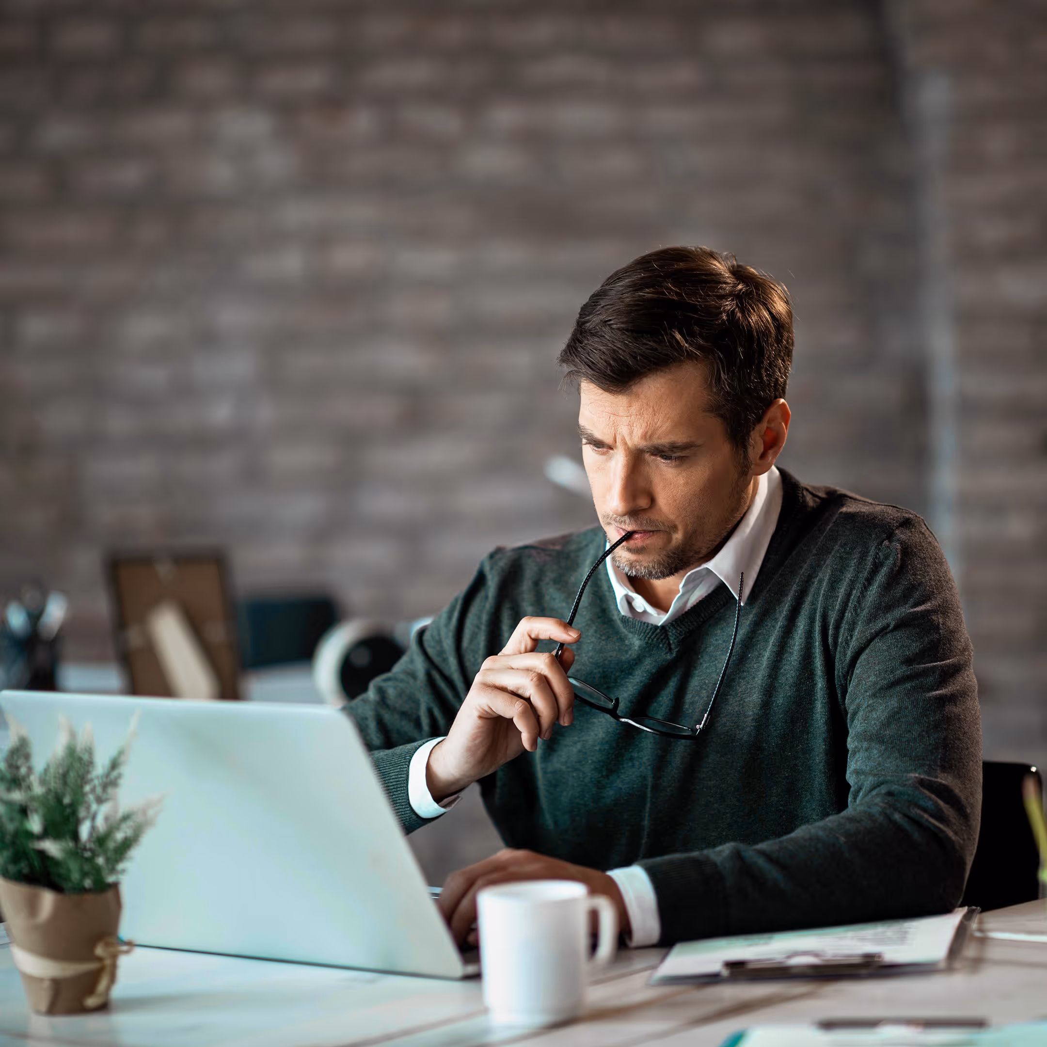 Serious businessman using laptop work contemplating about email he has received