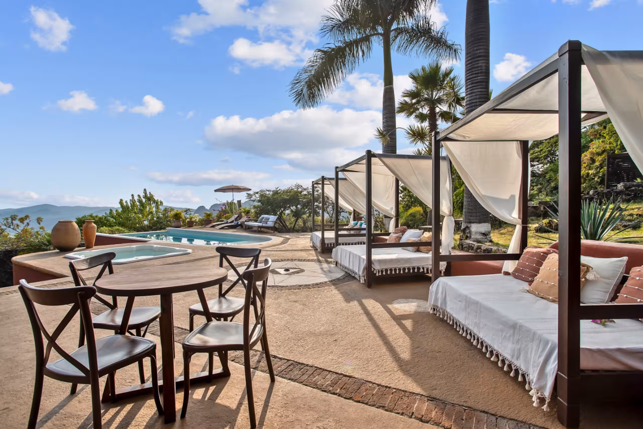 Canopied daybed on a wooden deck overlooking the valley.
