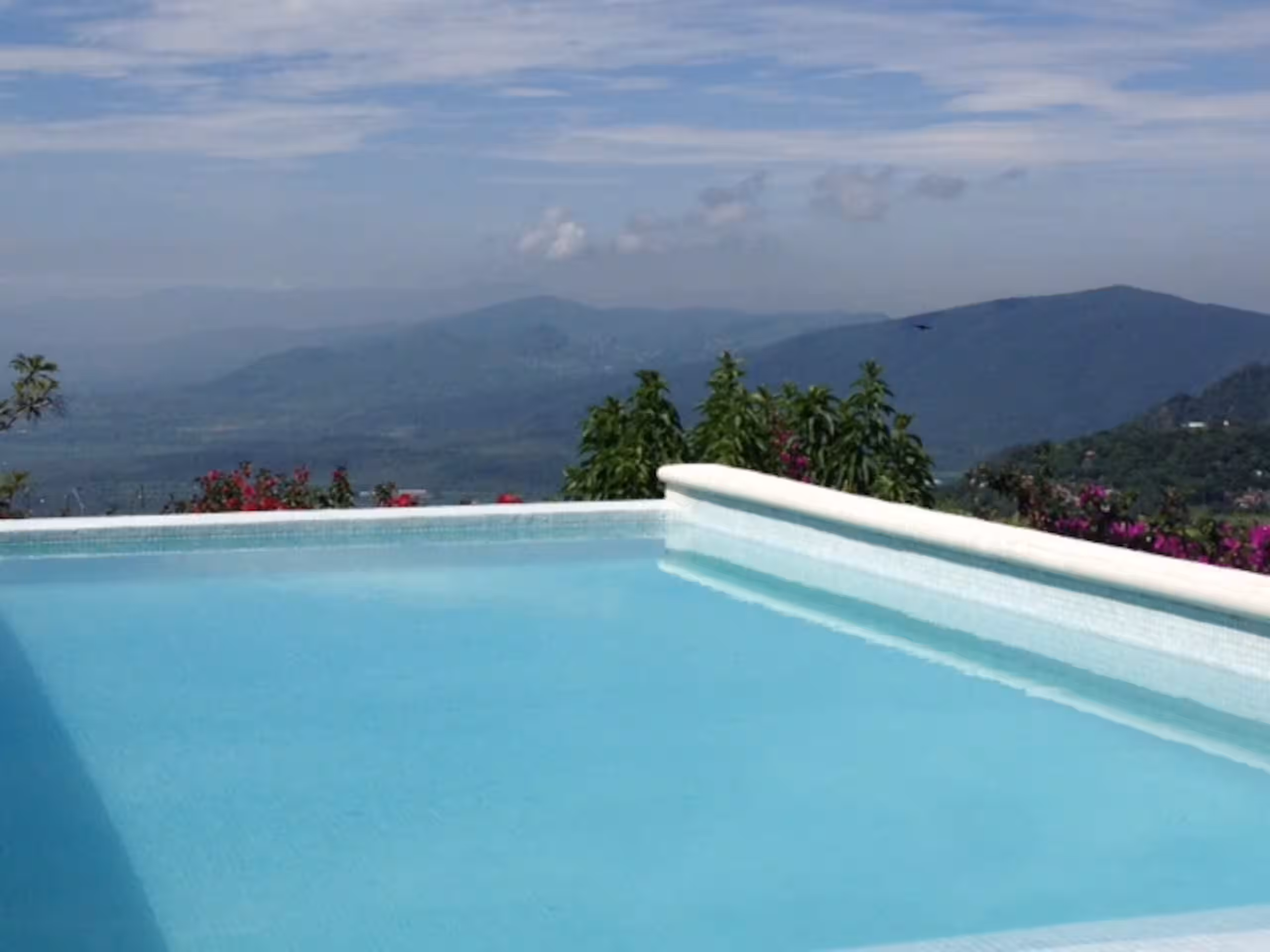 Pool running the length of the terrace, mountains across the valley.
