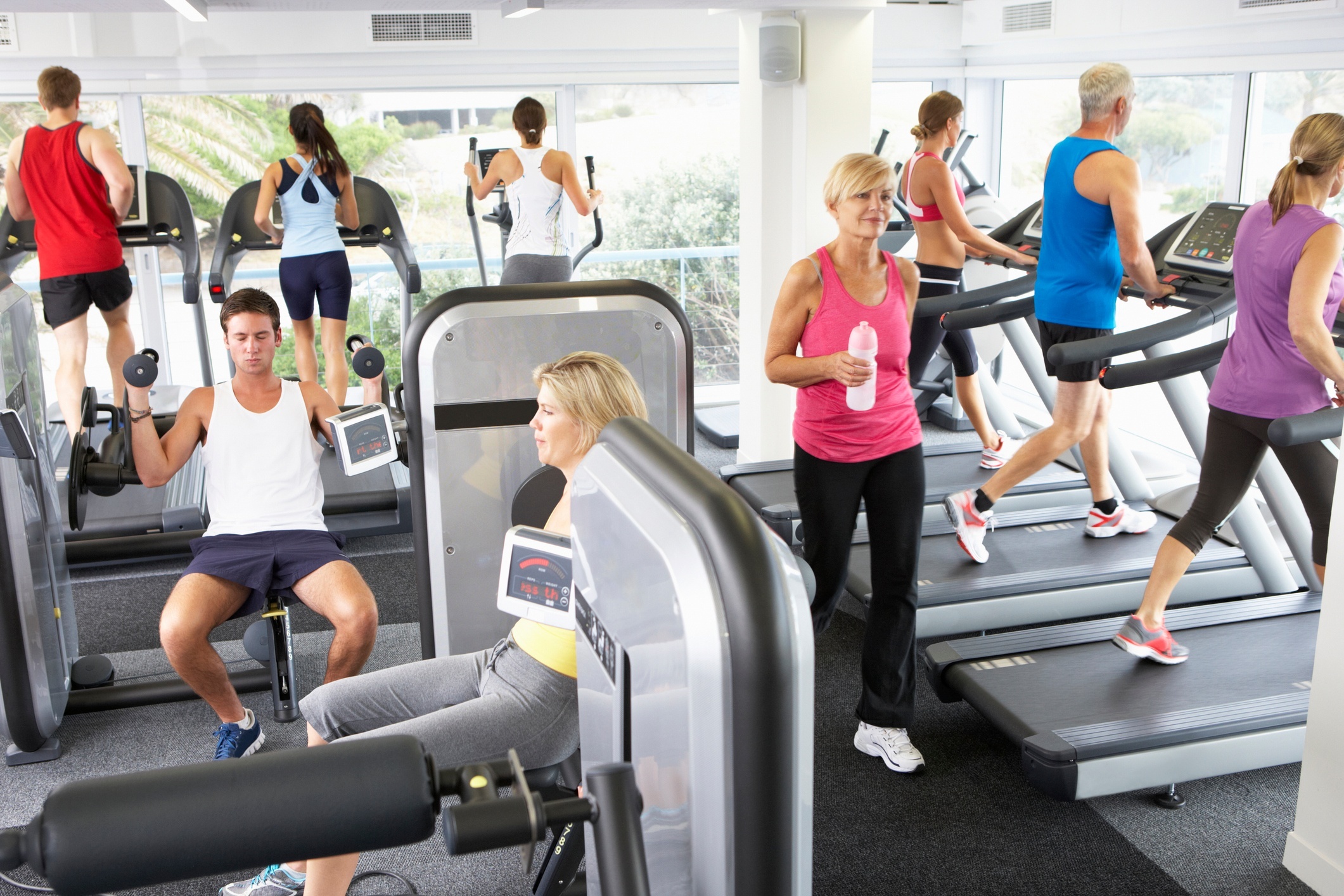 A crowded gym with no privacy and all equipment occupied.