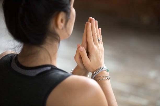 A woman doing the prayer wrist exercise to manage carpal tunnel.