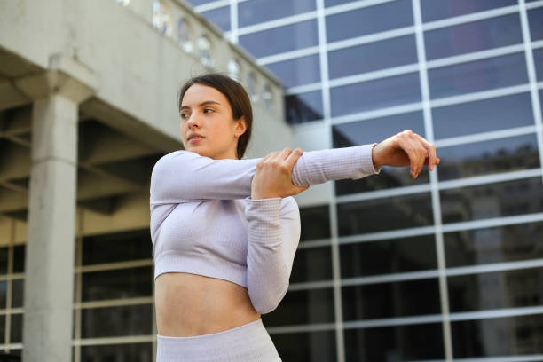 Woman in the cross-body stretch as a shoulder pain exercise.
