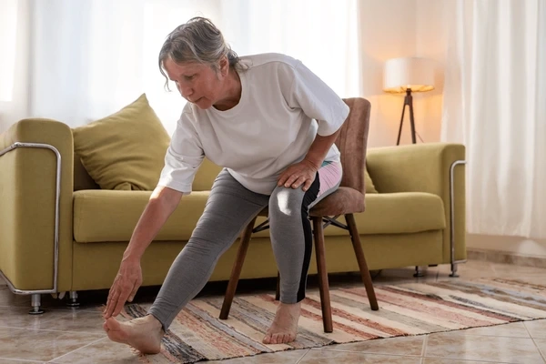 An older woman doing chair yoga to lose weight.