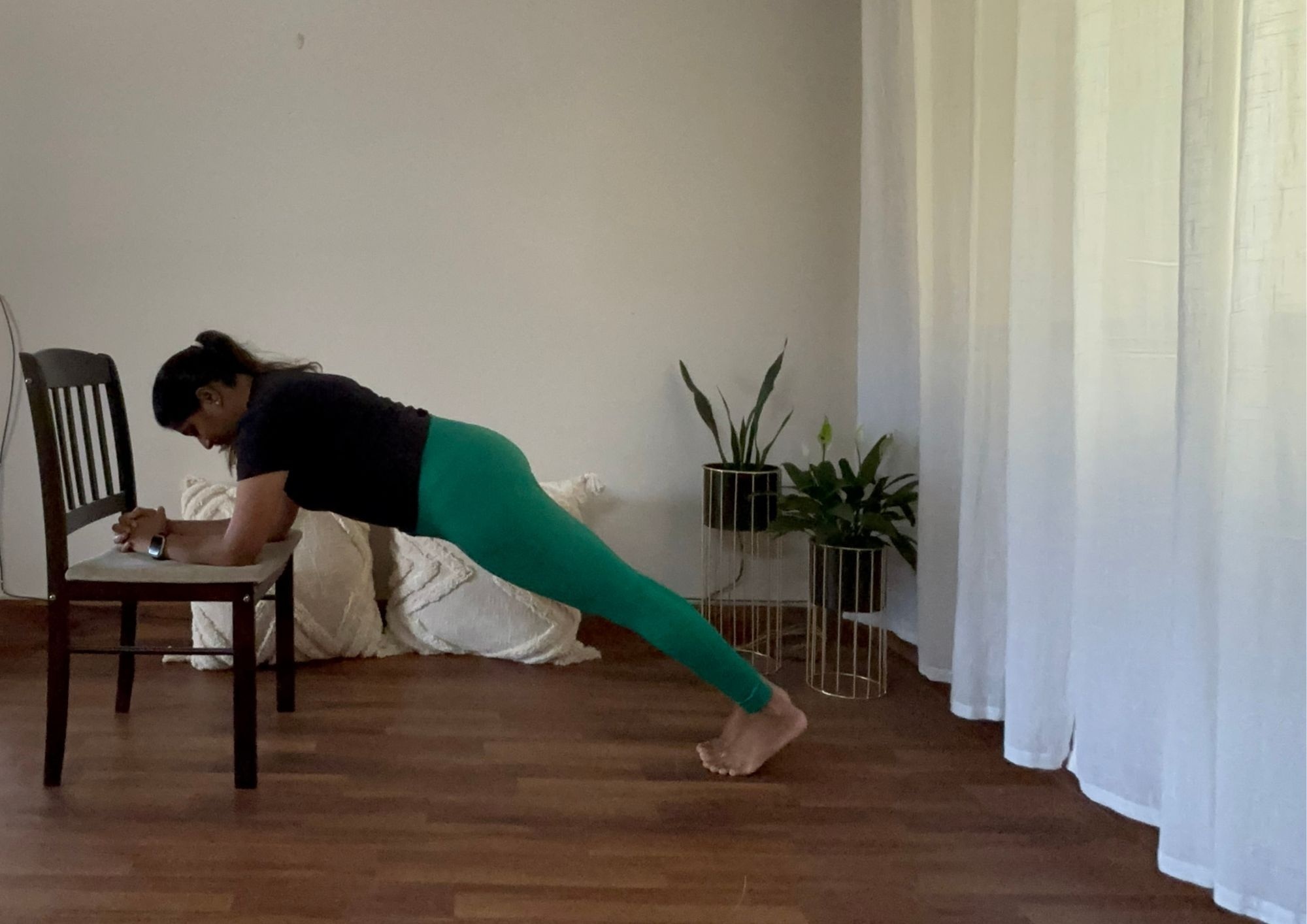 A woman doing chair planks for weight loss.