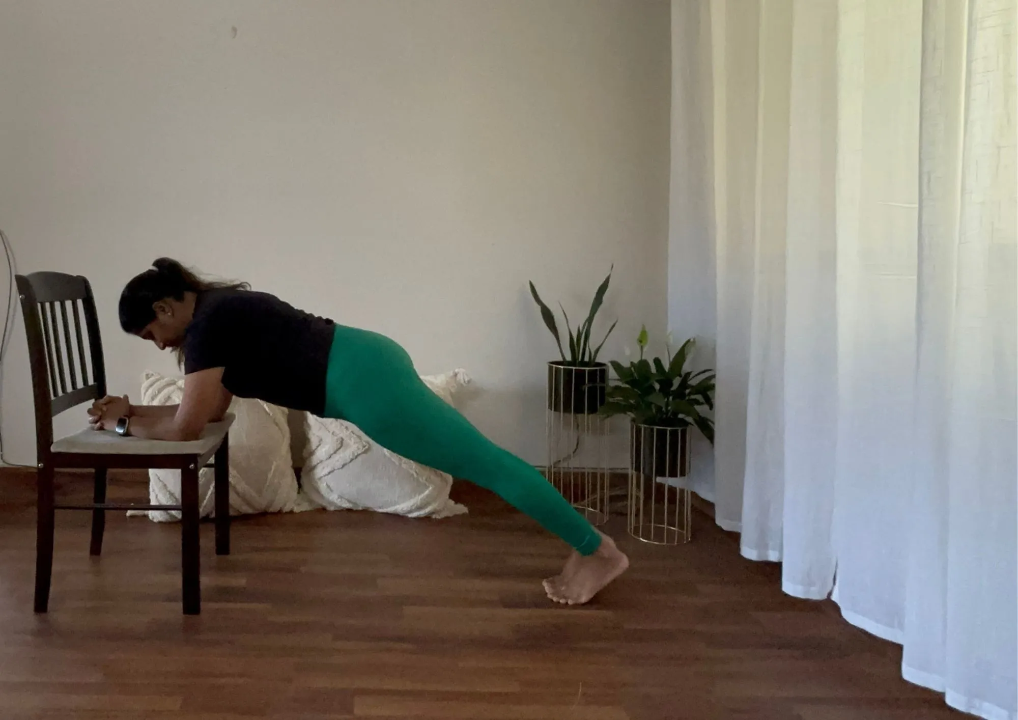 A woman doing chair planks for weight loss.