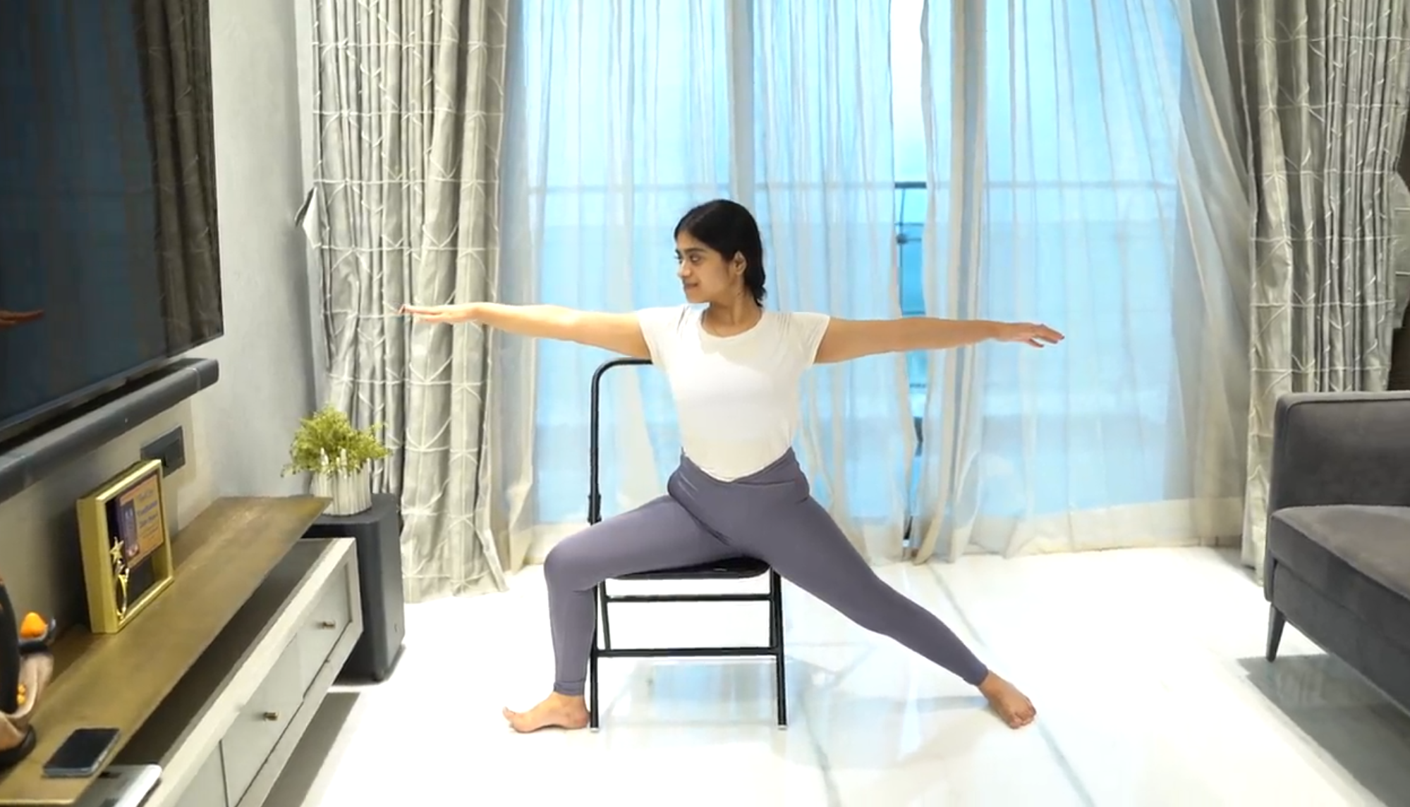 A woman doing the chair warrior pose to burn calories and reduce weight.