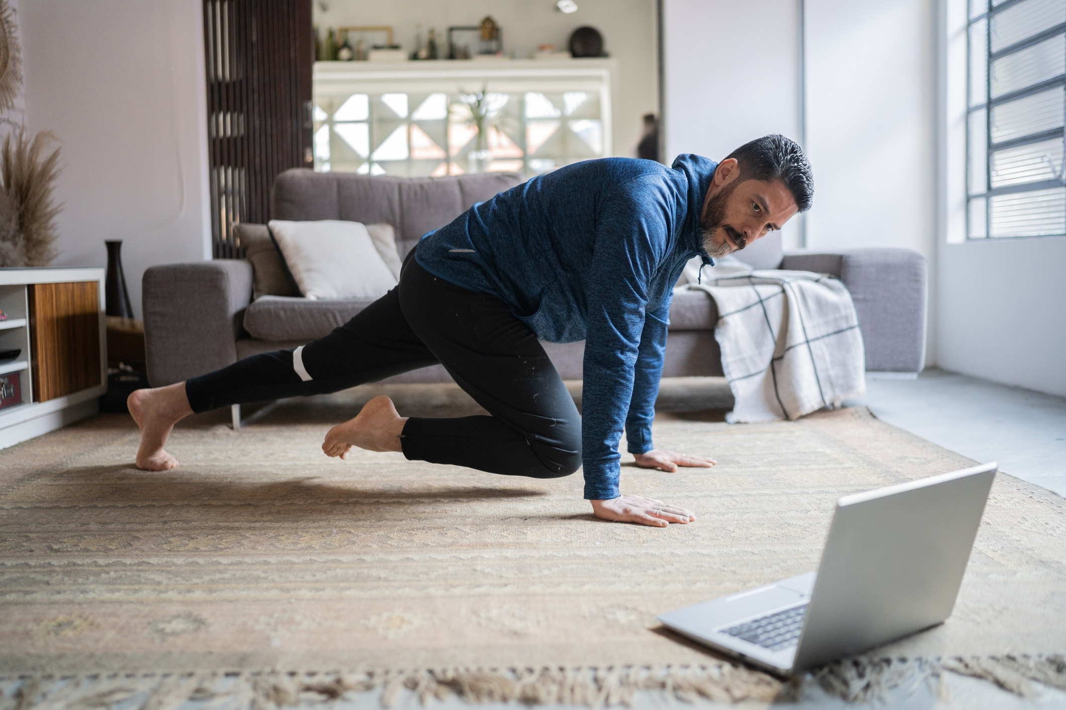 Mature-man-doing-online-exercise-class-at-home-1332112314_2124x1416.jpeg Man taking a 1-on-1 fitness coaching session with a MyYogaTeacher coach.
