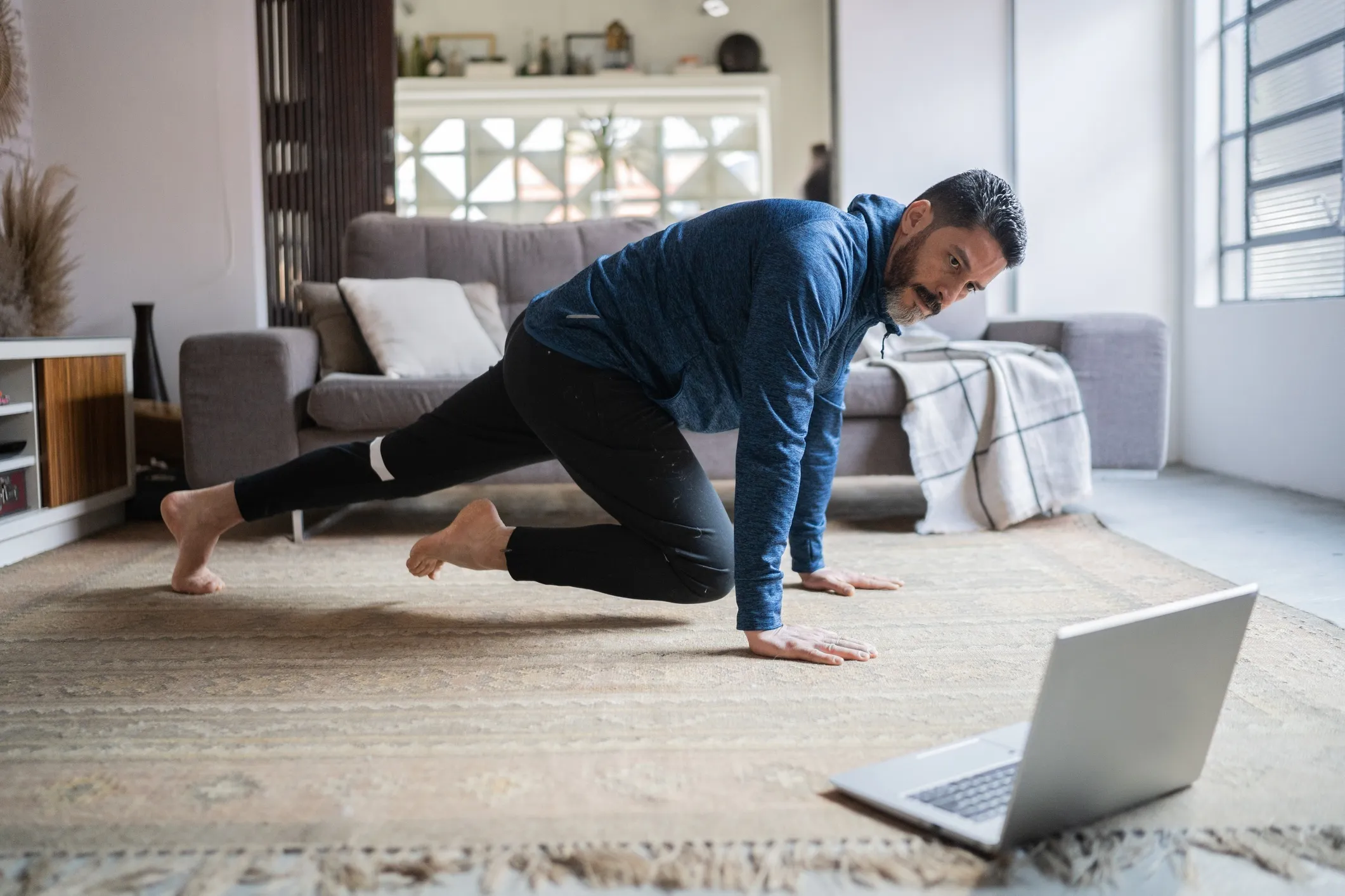 Mature-man-doing-online-exercise-class-at-home-1332112314_2124x1416.jpeg Man taking a 1-on-1 fitness coaching session with a MyYogaTeacher coach.
