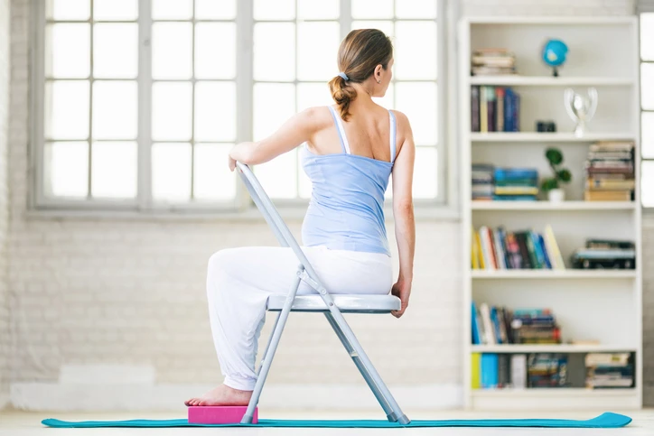 A women practicing chair yoga at home