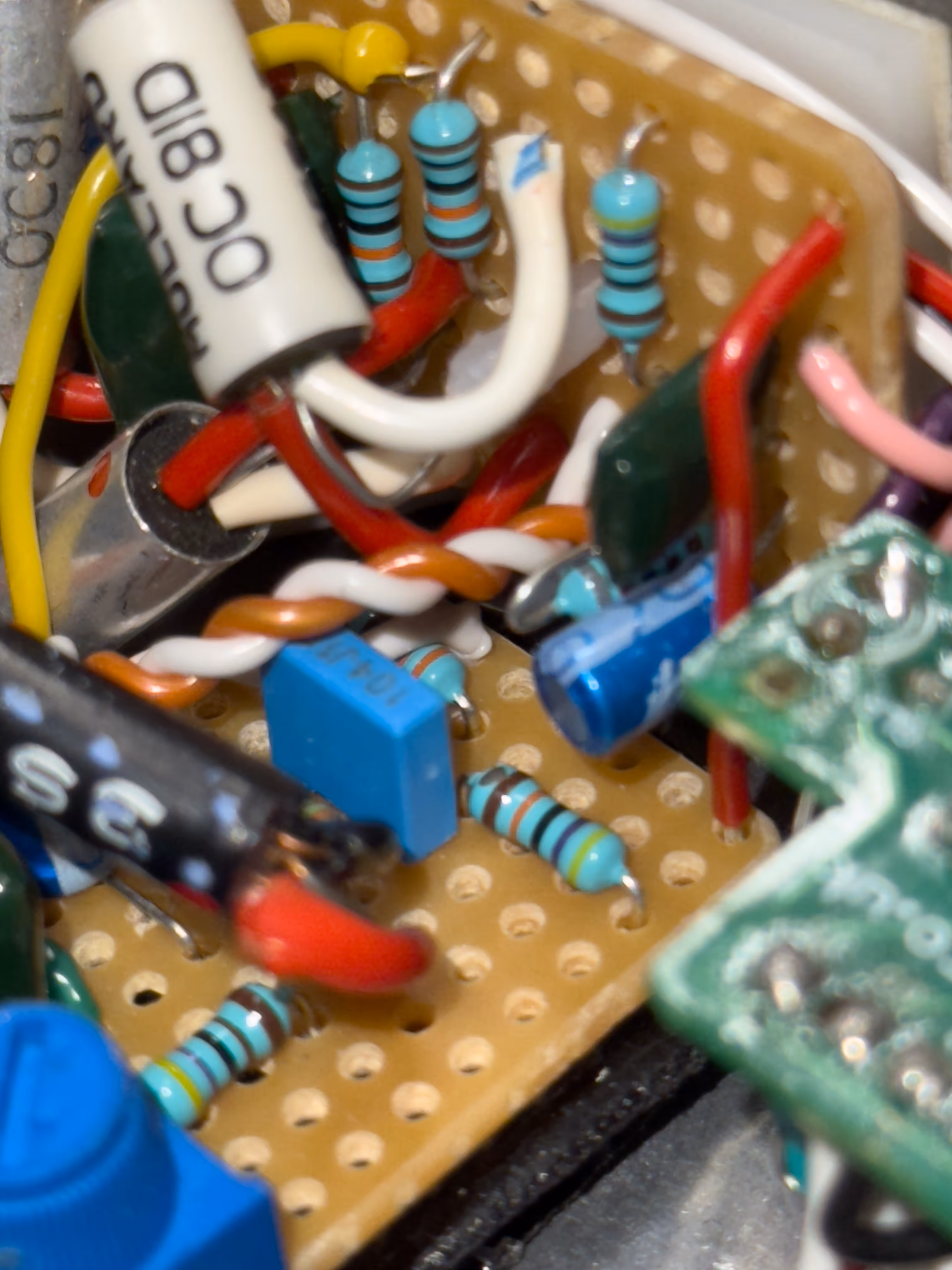 A picture of the inside of a handbuilt guitar pedal by Centric Engineering, showing the input jacks, resisistors, capacitors, original 60s Mullard transistors and circuit boards.